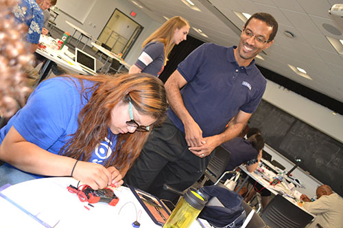 CISTEME365 PI Lynford Goddard watches as the Sarah E. Goode STEM Academy’s Post-Secondary Coach, Nancy Rodriguez, tests the circuit she built.