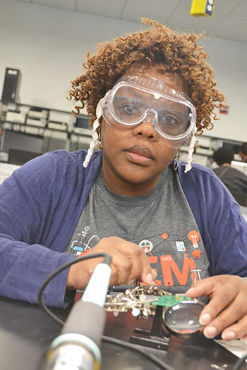 Anita Alicea, a STEM integration specialist at Sarah E. Goode STEM Academy, soldering a circuit.