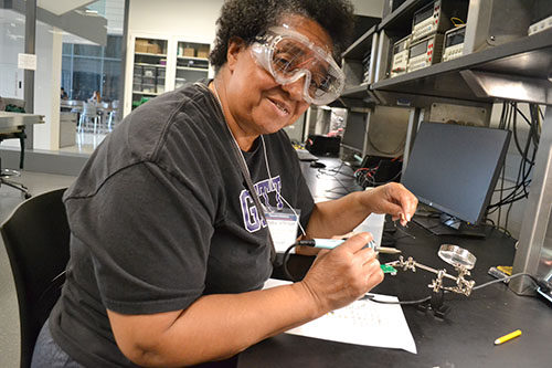 Chicago Vocational Career Academy English teacher Zenobia Jefferson enjoying the soldering hands-on activity.