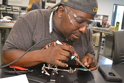Lemond Peppers, a student engagement advocate from Urbana High School, solders the circuit he’s making.