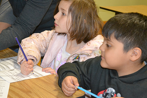 Two youngsters listen while a lesson about heat and temperature is presented.