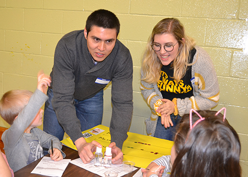 Two Illinois students do an activity with young visitors during Cena y Ciencias