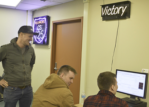 Challen watches two students work. In the top right is the celebratory