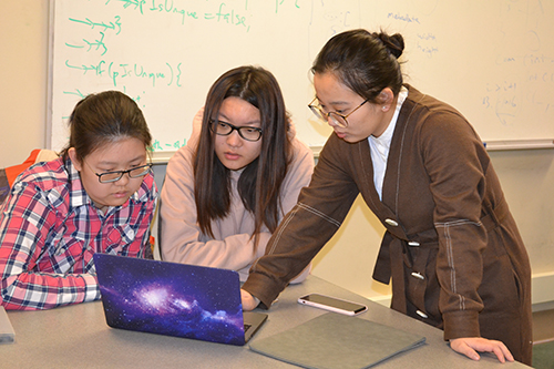 Two  CAs (right) help a student in CS125.