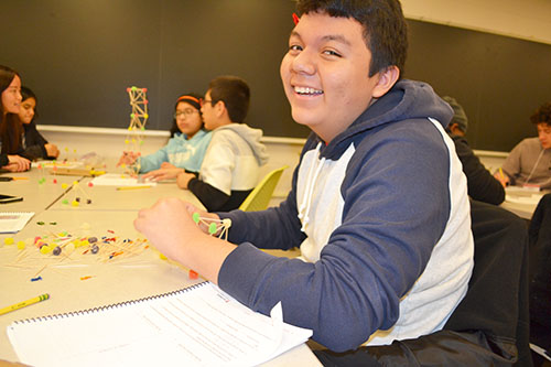 A ChiS&E seventh grader enjoys making his team's toothpick-gumdrop structure.
