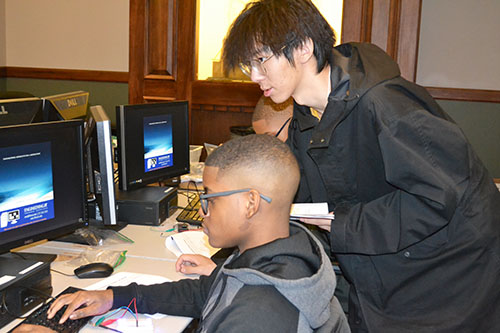 An Illinois engineering student (right)  works with a Chicago eighth grader during the Computer Science activity.