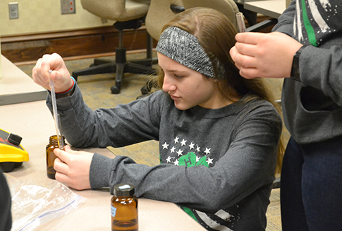 A student adds sodium citrate to hydrogen tetracholoroaurate to make gold nanoparticles.