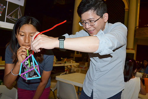 At the Orpheum, Adriana Coariti (left) uses a straw to blow a bubble inside a larger bubble Jie Feng created with the 3D wand he designed.