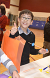 A boy makes a rubberband helicopter at STEAM Night