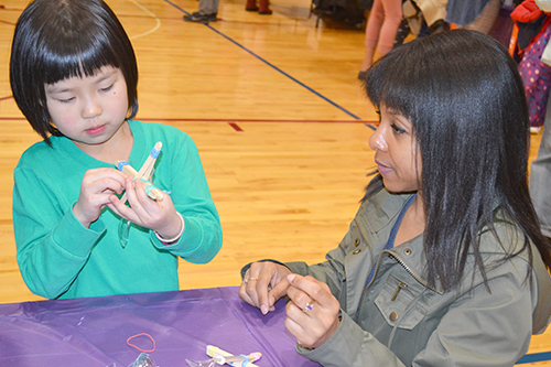 Lonna Edwards (right) helps a student build a catapult.