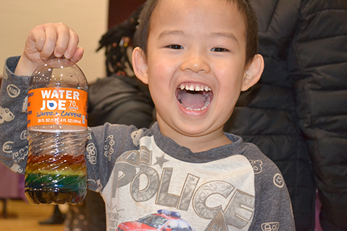 A youngster gleefully shows off the Rainbow Jar he made.
