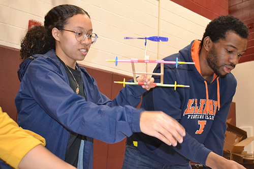 Ashley Mitchell (left) helps a youngster with their rubberband helicopter.
