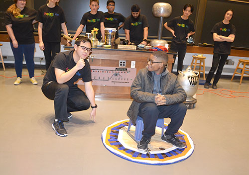 Above: A Physics Van volunteer interacts with a Chicago student who is helping out with a demo which involves making the whole pad his stool is on move...with him seated on it.