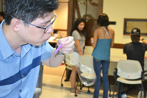 MechSE Assistant Professor Jie Feng demonstrates for high school students at WYSE camp principles about bubbles.