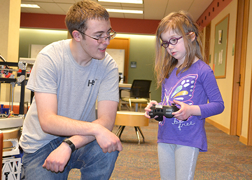 An iRobotics member teaching a local youngster how to operate the robot.