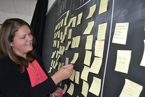 Meagan Pollock examines notes teachers posted on the blackboard regarding their aha moments during the training.