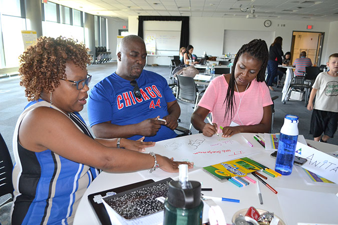 A team works on their poster about students' perceptions of what STEM is.