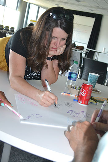 Irica Baurer, a Fine Arts Teacher at  Sarah E. Goode STEM Academy, works on her team’s poster depicting students’ perception of what STEM is.