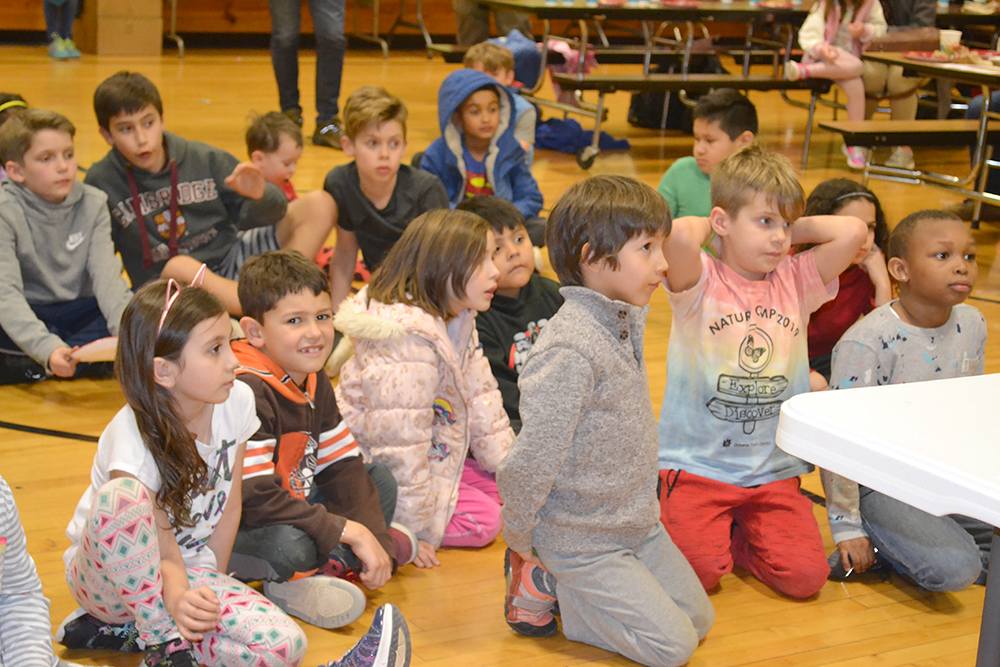 Children at the March 2nd Cena y Ciencias watch Felipe Menanteau perform a demonstration about heat and temperature