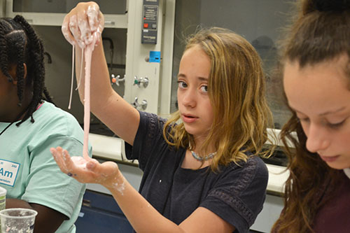 A camper plays with slime during one of the hands-on activities.