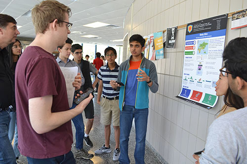 Joe Muskin and Christopher Aksland  watch as a Uni High student gives his team's presentation.