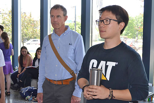 David Bergandine (center) and Andy Yoon (right) watch a team give their presentation.