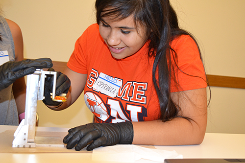 Esperanza removes the Batmobile she 3D printed using a razor blade.