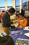 Tianshi Fu (left) helps a Uni High student doing one of the soft robotics hands-on activities during Agora Days. (Image courtesy of Holly Golecki.)