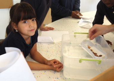 Young technology club member waits to test her boat.