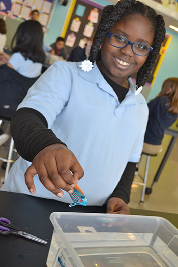 A BTW fourth grader prepares to test her robotic fish.