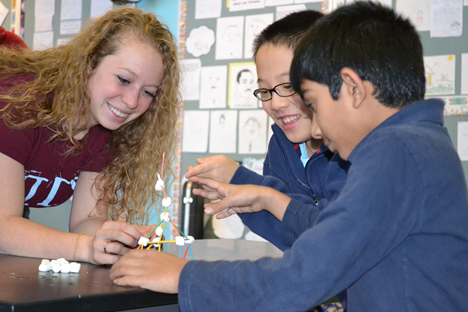 Engineering student Taylor Oltman works with students during a spring 2014 session of the BTW Engineering Club.