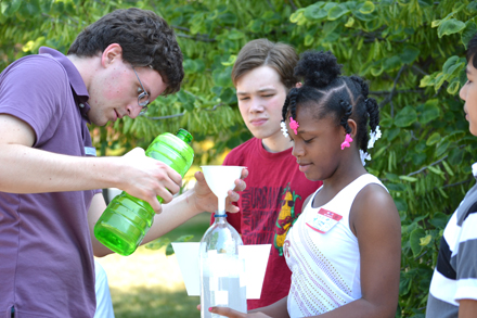 Drew Coverdill (left) and campers filling bottle rocket prior to launch.