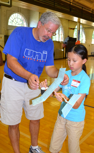 Bob Coverdill helps young camper prepare her glider for flight.