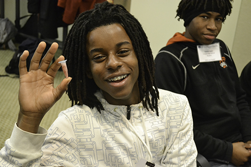 A student shows the DNA he extracted from strawberries during a DNA & Health Day activity.