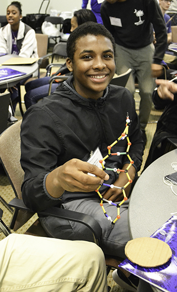 A UHS student shows his team's DNA structure.