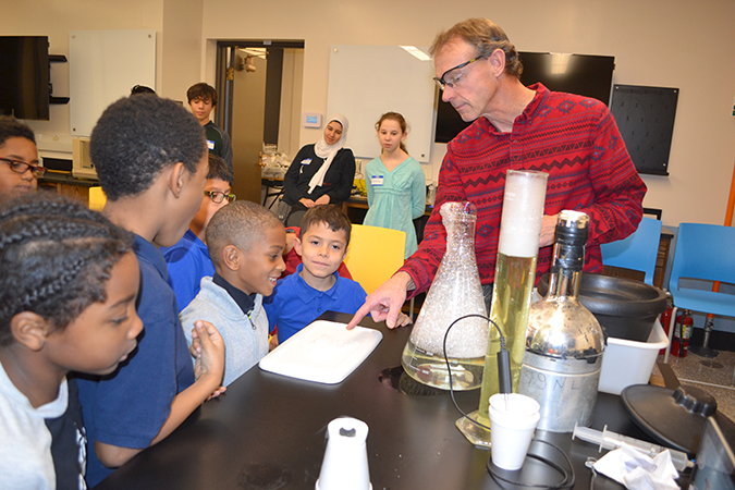 David Bergandine (right) teaches local boys about science during his liquid nitrogen activity, part of Uni-DREAAM Connect after-school activities on December 12th. 