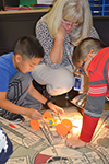 Fourth grade teacher Jennifer Simmons looks on as two of her students test their solar car.