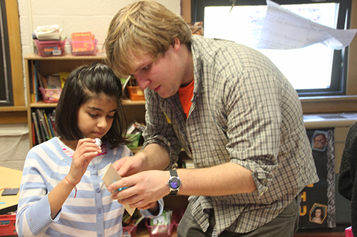 Peter Sokalski (right) helping a fourth grader build her solar car. (Image courtesy of Joe Muskin.)