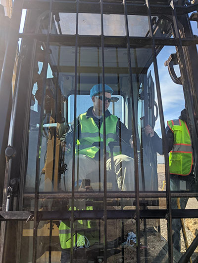 Dylan Taylor seated in a Caterpillar Excavator during his and Team 36's visit to the plant in Peoria. (Image courtesy of Team 36's final presentation.)