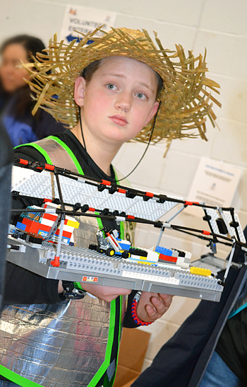 FLL Contestant holds his team's robot.