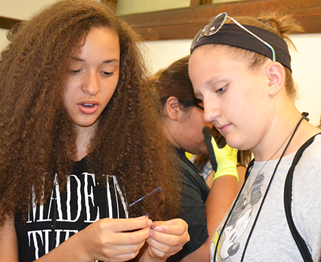 G.A.M.E.S. counselor Grace Pekeltis (right), a sophomore in Materials Science Engineering, and a GLAM camper examine the camper's  memory metal.