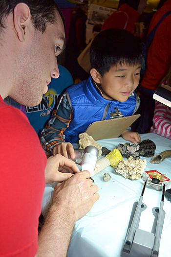 Jim Bruce supervises while a local youngster uses the ProScope to magnify rocks and coral.