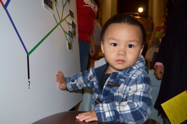 Genome Day had something of interest for all ages. Here a 23-month-old youngster finds one of the displays intruiguing