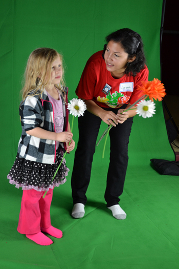Local youngster and Illinois graduate student stand in front of a green screen so they can "dance with plants."