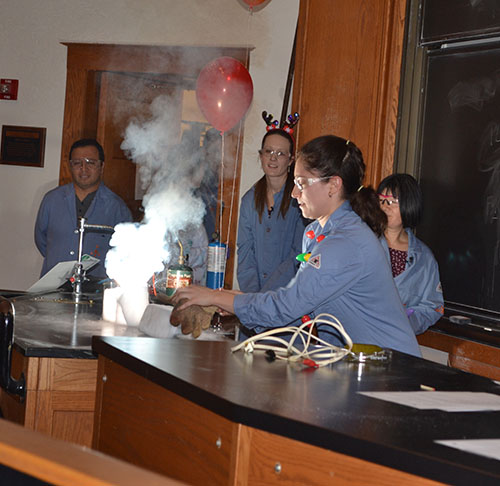 The exothermic chemical reaction in the demo done by Jordan Axelson produces a number of byproducts: heat, light, gas, smoke.