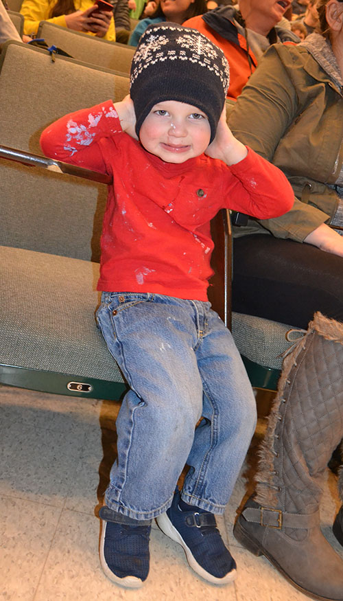 A young member of the audience prepares for the next demo, which he suspects will be a noisy one.