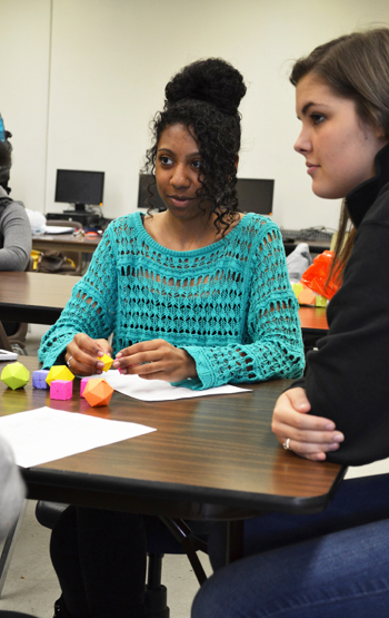 Local high school student uses geometric shapes to conceptualize a math principle during a Tap-In afterschool program at Centennial.