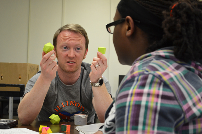 Noel DeJarnette uses geometric figures to explain a math principal to a Tap-In student at Centennial High.