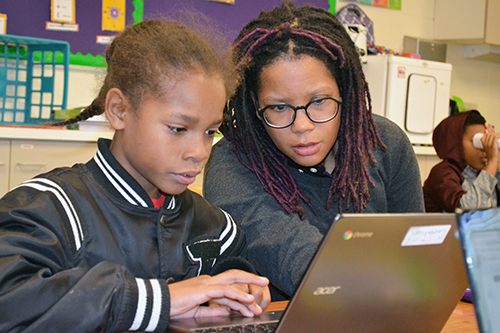 King's Shalonda Carr works with a student who is using TinkerCAD to design a keychain.