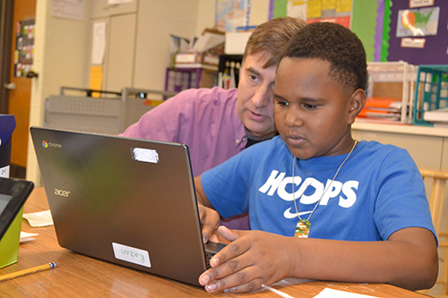 As part of the Paper2Tree outreach activities, MechSE Outreach Coordinator Joe Muskin (left), works with a King student who is using TinkerCAD to design a keychain which will then be 3D printed.